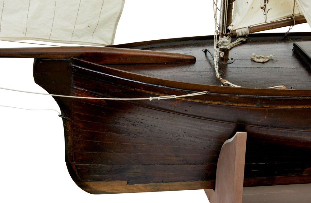 A late 19th-century wooden scale model of a two-masted sailing yacht with off-white sails mounted on a wooden stand. View VIII