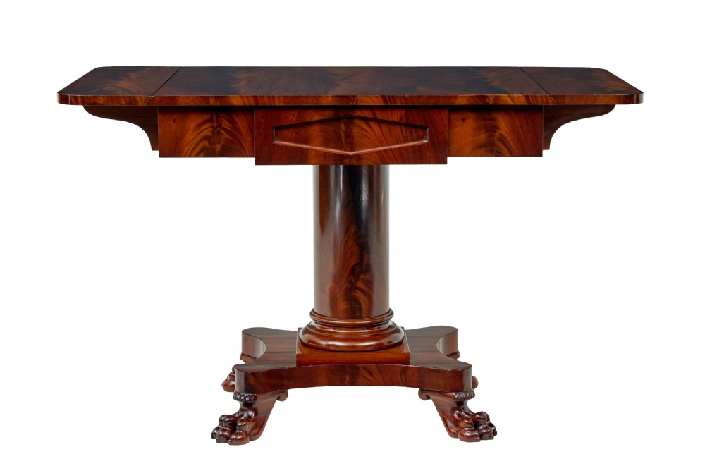 An early 20th-century Scandinavian Empire Revival mahogany sofa table featuring drop leaves, a single frieze drawer, a central cylindrical pedestal, and carved paw feet. View IV