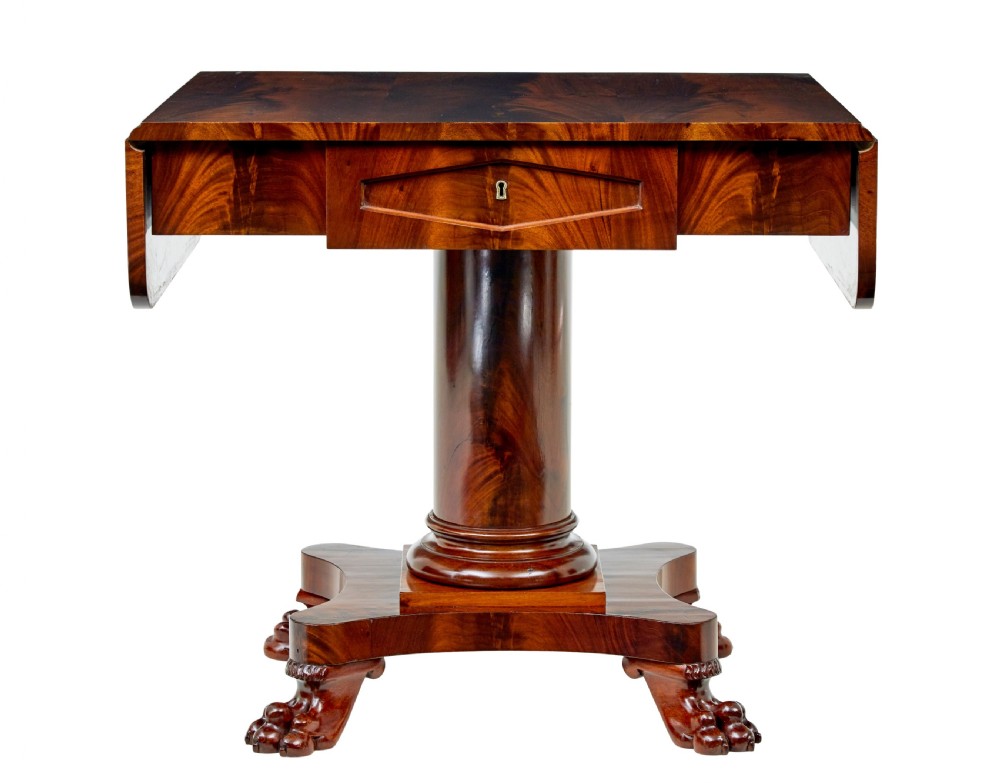 An early 20th-century Scandinavian Empire Revival mahogany sofa table featuring drop leaves, a single frieze drawer, a central cylindrical pedestal, and carved paw feet. View IX