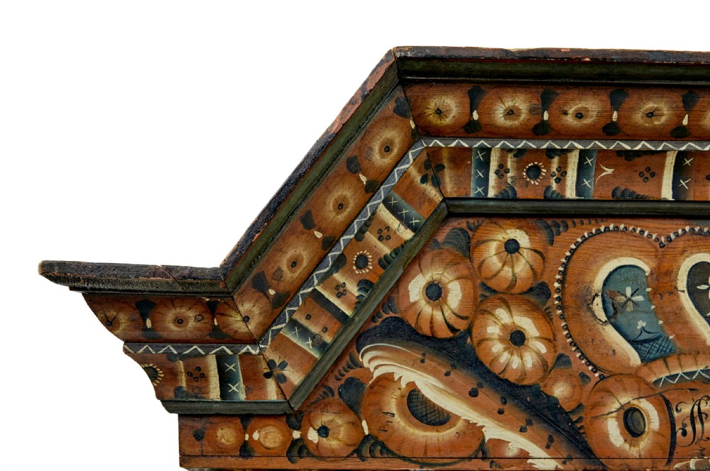 An early nineteenth-century Swedish painted wooden cupboard featuring floral folk art motifs, a shaped cornice dated 1804, and turned bun feet. View III