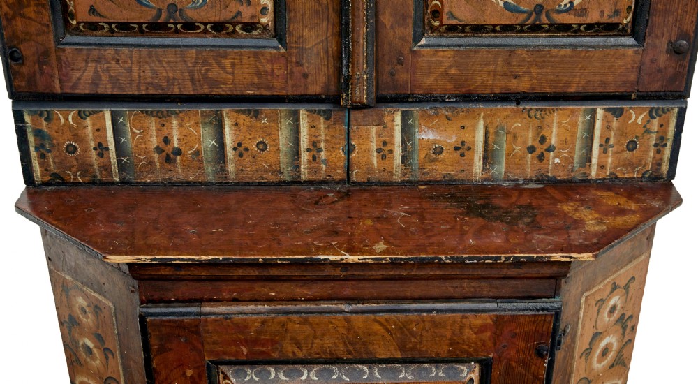 An early nineteenth-century Swedish painted wooden cupboard featuring floral folk art motifs, a shaped cornice dated 1804, and turned bun feet. View VI