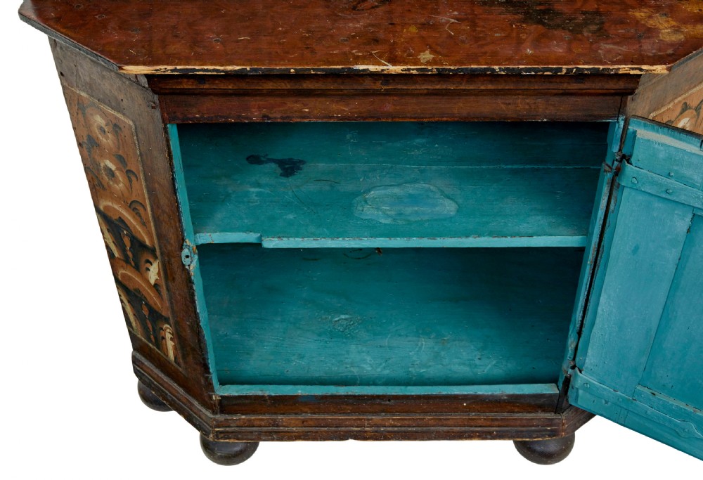 An early nineteenth-century Swedish painted wooden cupboard featuring floral folk art motifs, a shaped cornice dated 1804, and turned bun feet. View VII