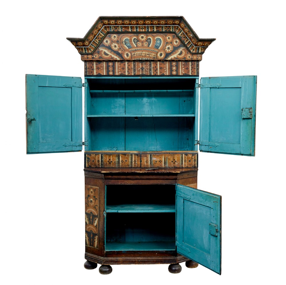 An early nineteenth-century Swedish painted wooden cupboard featuring floral folk art motifs, a shaped cornice dated 1804, and turned bun feet. View VIII