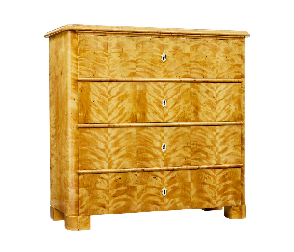 A nineteenth-century Swedish chest of drawers featuring four drawers decorated with book-matched tiger birch veneer and small white escutcheons.