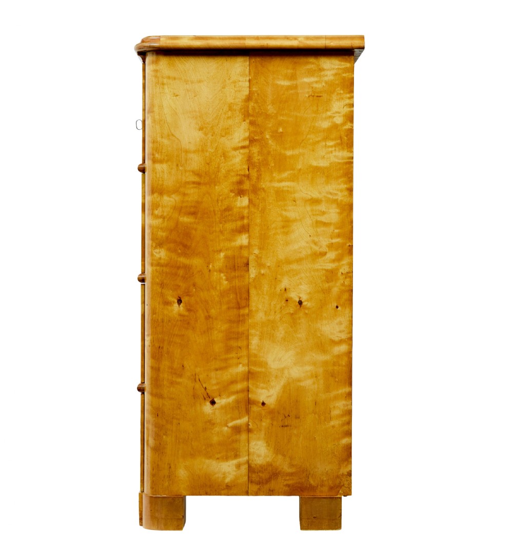 A nineteenth-century Swedish chest of drawers featuring four drawers decorated with book-matched tiger birch veneer and small white escutcheons. View IV