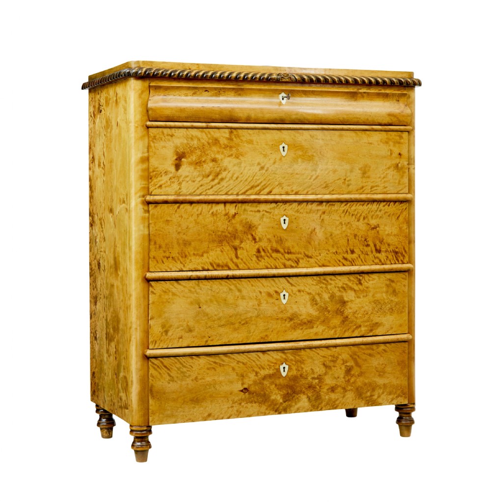 A 19th-century Swedish birch chest featuring five graduated drawers with keyhole escutcheons, rope-carved moulding under the top edge, and turned feet.