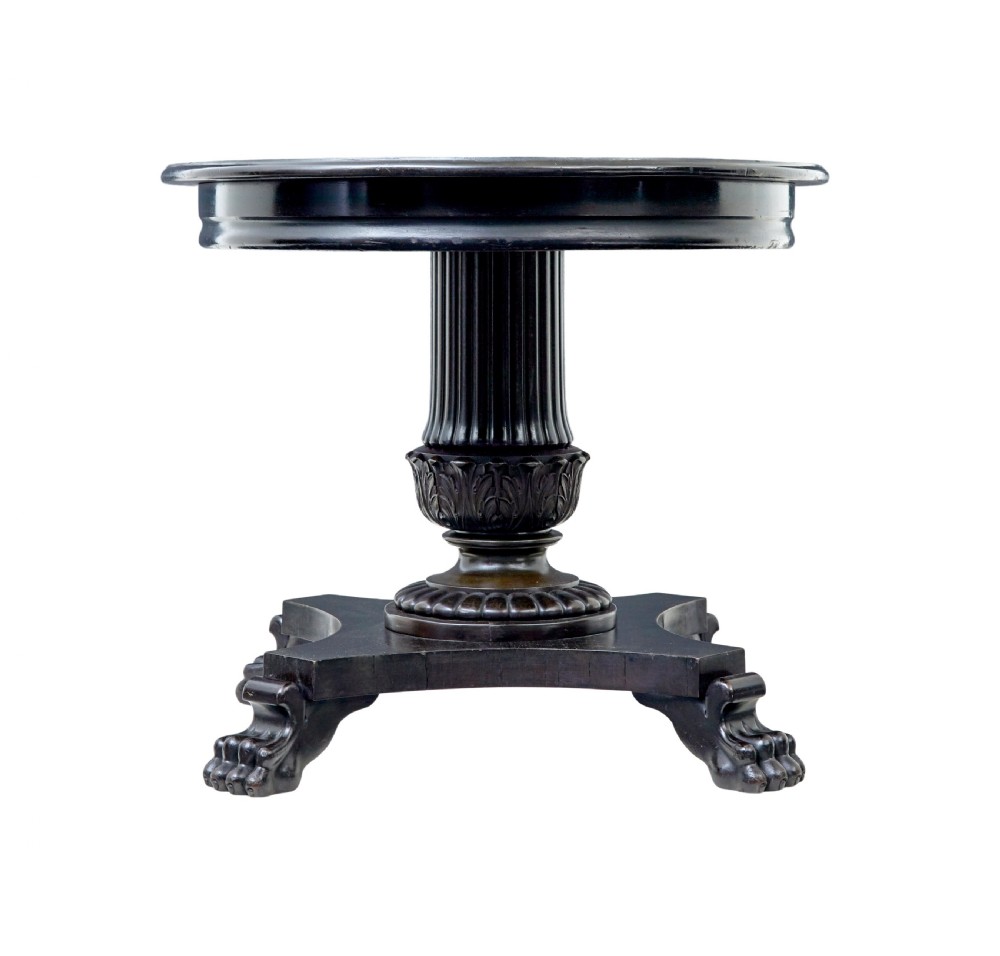 A 19th-century ebonised dark wood oval centre table featuring a fluted central pedestal and a quadform base supported by carved claw feet. View III