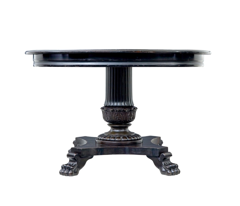 A 19th-century ebonised dark wood oval centre table featuring a fluted central pedestal and a quadform base supported by carved claw feet. View IV