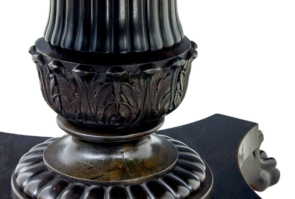 A 19th-century ebonised dark wood oval centre table featuring a fluted central pedestal and a quadform base supported by carved claw feet. View VII