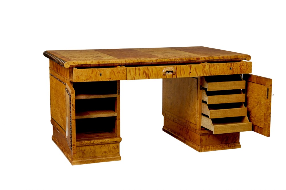 An Art Deco twin-pedestalled desk crafted from golden flame birch veneer featuring multiple drawers, cupboard doors, and decorative reeded borders. View II