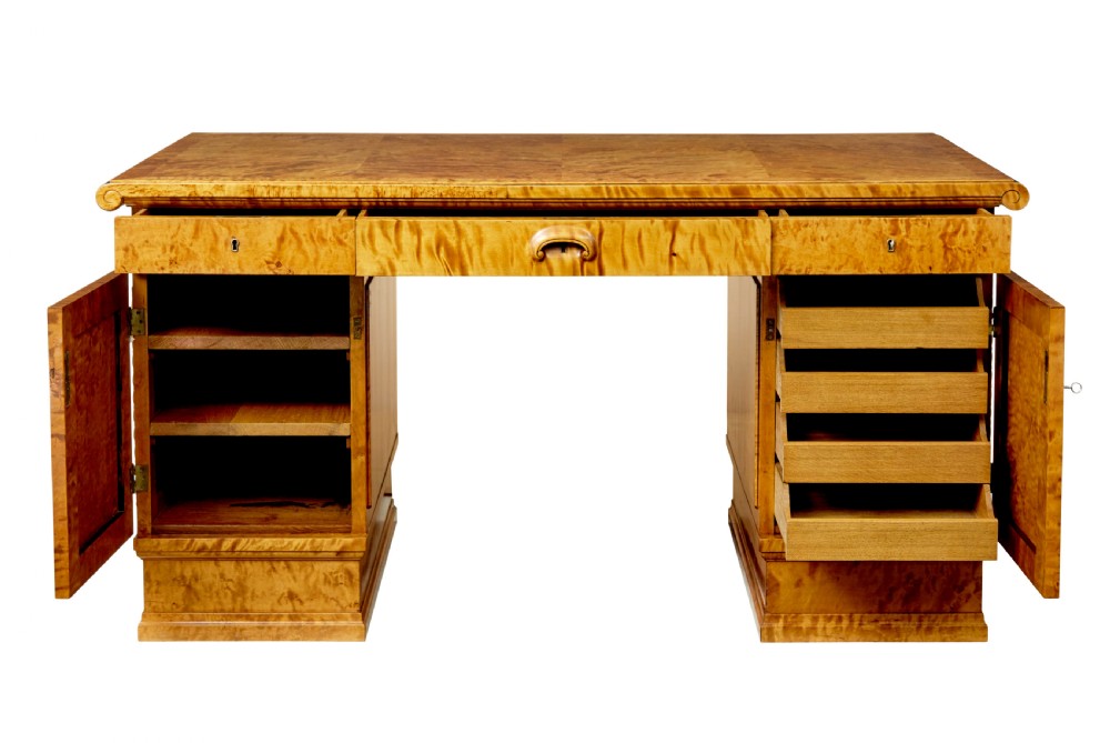An Art Deco twin-pedestalled desk crafted from golden flame birch veneer featuring multiple drawers, cupboard doors, and decorative reeded borders. View III