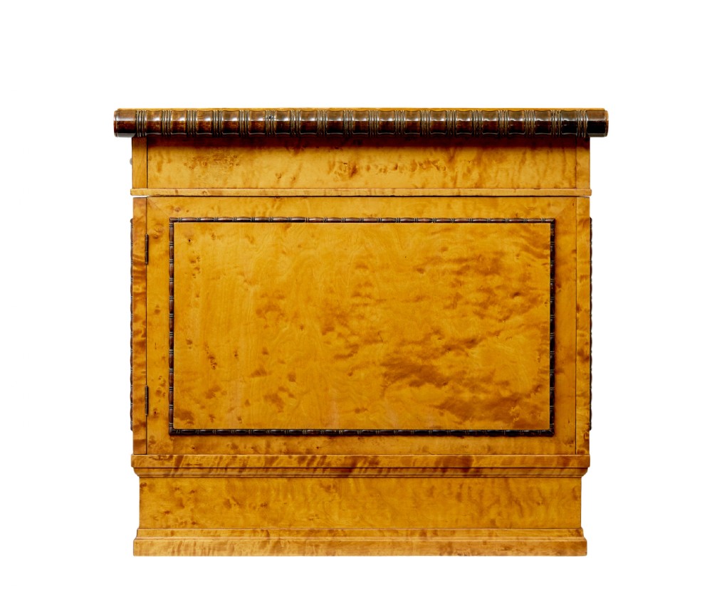 An Art Deco twin-pedestalled desk crafted from golden flame birch veneer featuring multiple drawers, cupboard doors, and decorative reeded borders. View V