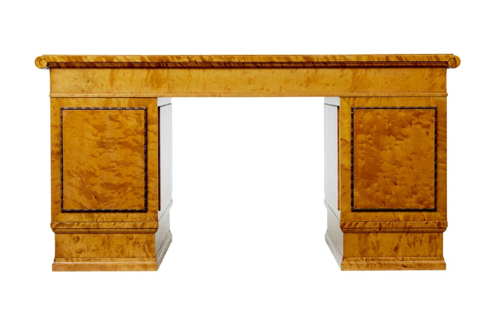 An Art Deco twin-pedestalled desk crafted from golden flame birch veneer featuring multiple drawers, cupboard doors, and decorative reeded borders. View VII