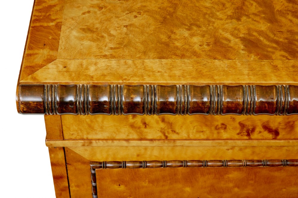 An Art Deco twin-pedestalled desk crafted from golden flame birch veneer featuring multiple drawers, cupboard doors, and decorative reeded borders. View IX