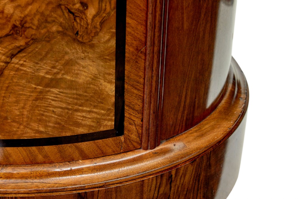 A 19th-century cylindrical burr walnut pedestal cupboard featuring geometric dark stringing and a single door with a key. View X