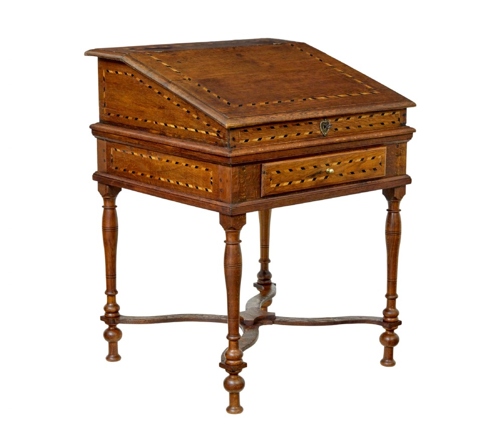 An early 19th-century Dutch oak writing desk on turned legs featuring geometric inlaid borders and a sloped writing lid above a single drawer.