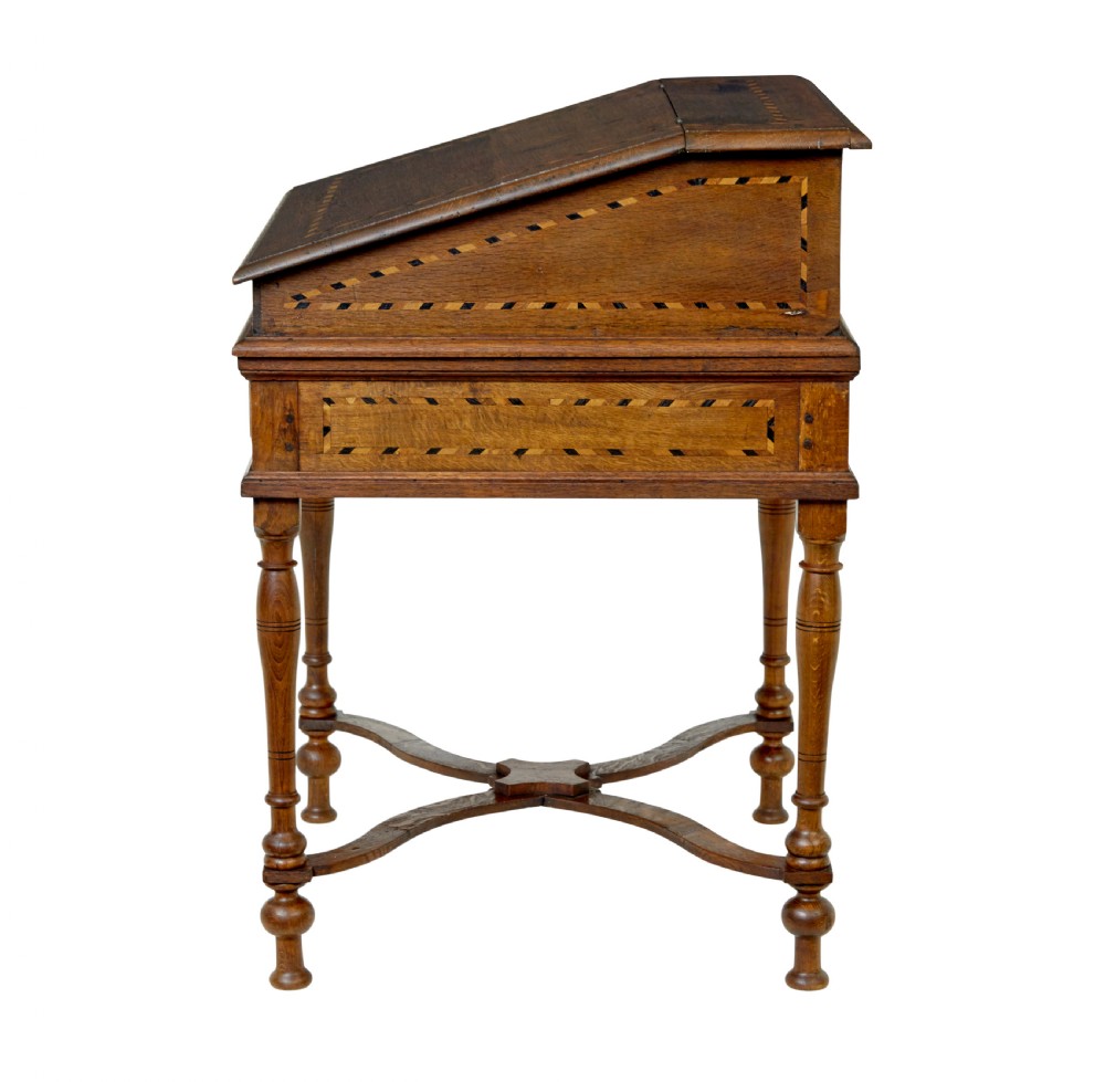 An early 19th-century Dutch oak writing desk on turned legs featuring geometric inlaid borders and a sloped writing lid above a single drawer. View IV