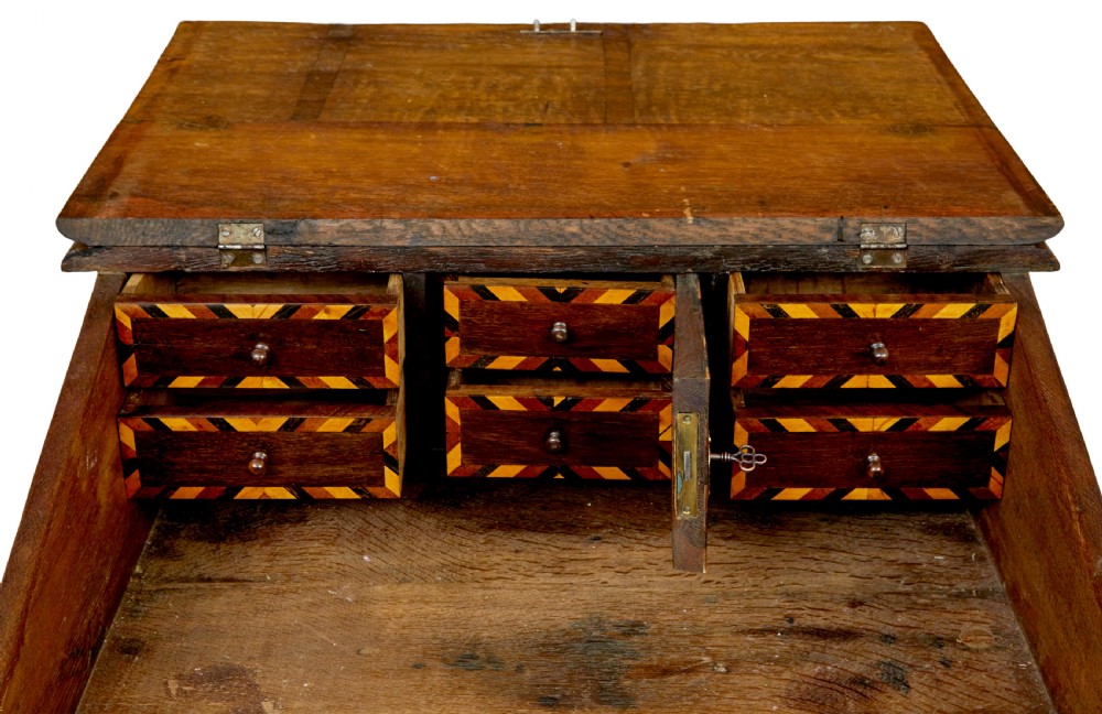 An early 19th-century Dutch oak writing desk on turned legs featuring geometric inlaid borders and a sloped writing lid above a single drawer. View X