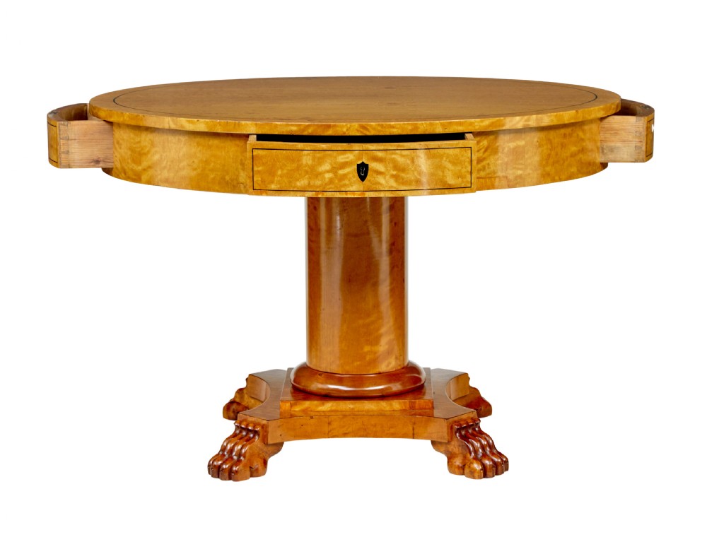 A circular 19th-century Swedish flame birch centre table featuring a single frieze drawer, a central cylindrical pedestal, and a shaped quadruped base resting on carved claw feet. View II