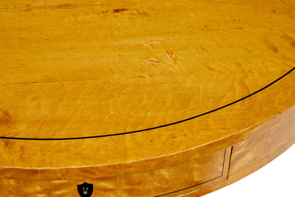 A circular 19th-century Swedish flame birch centre table featuring a single frieze drawer, a central cylindrical pedestal, and a shaped quadruped base resting on carved claw feet. View IV
