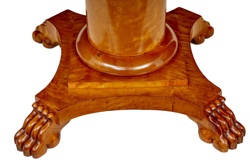 A circular 19th-century Swedish flame birch centre table featuring a single frieze drawer, a central cylindrical pedestal, and a shaped quadruped base resting on carved claw feet. View V