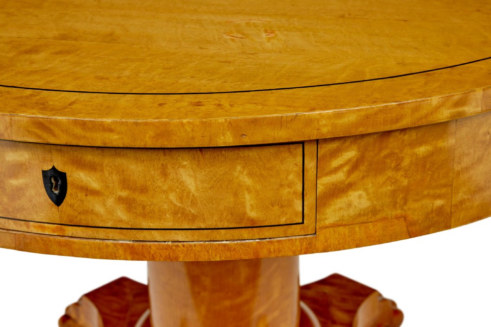 A circular 19th-century Swedish flame birch centre table featuring a single frieze drawer, a central cylindrical pedestal, and a shaped quadruped base resting on carved claw feet. View VI