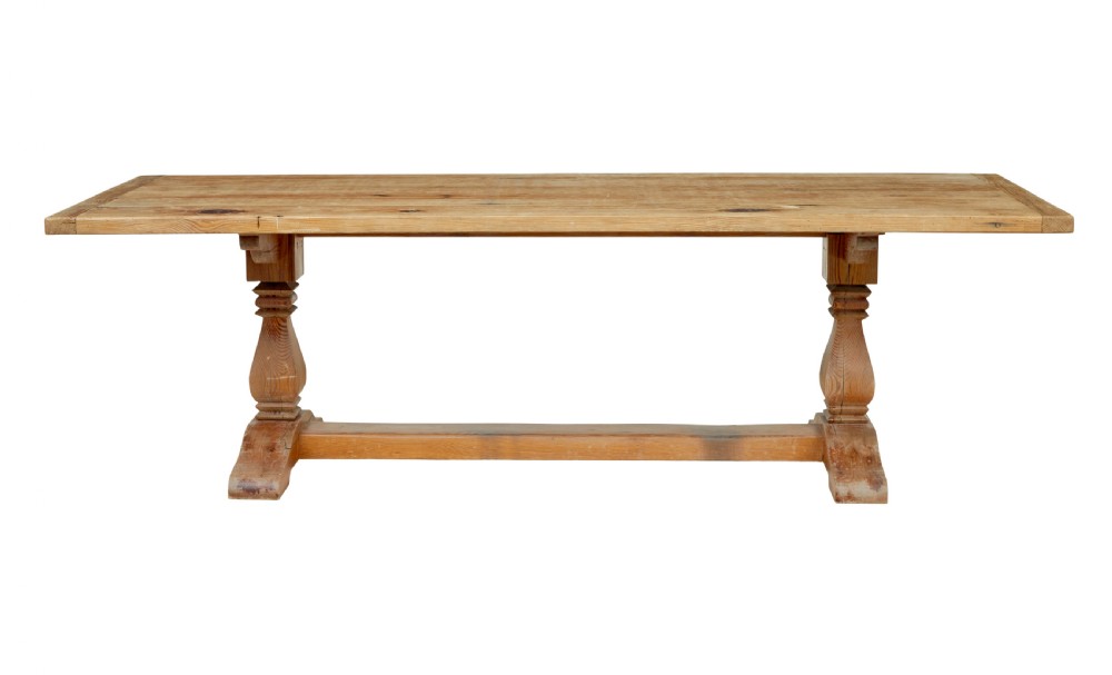 A nineteenth-century pine refectory dining table featuring a plank top, carved baluster supports, and a low central floor stretcher. View II