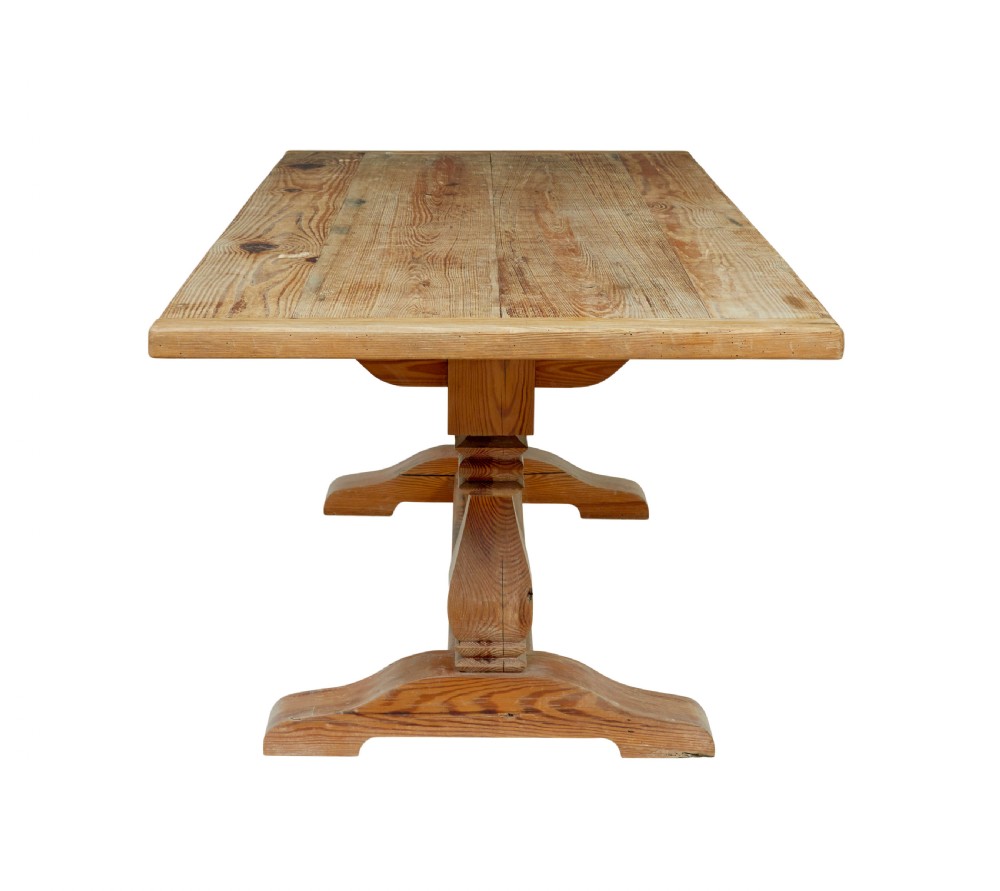 A nineteenth-century pine refectory dining table featuring a plank top, carved baluster supports, and a low central floor stretcher. View III