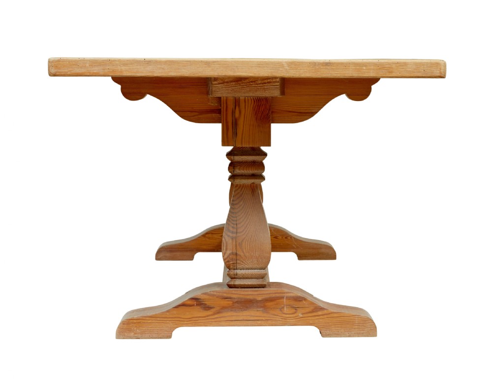 A nineteenth-century pine refectory dining table featuring a plank top, carved baluster supports, and a low central floor stretcher. View IV