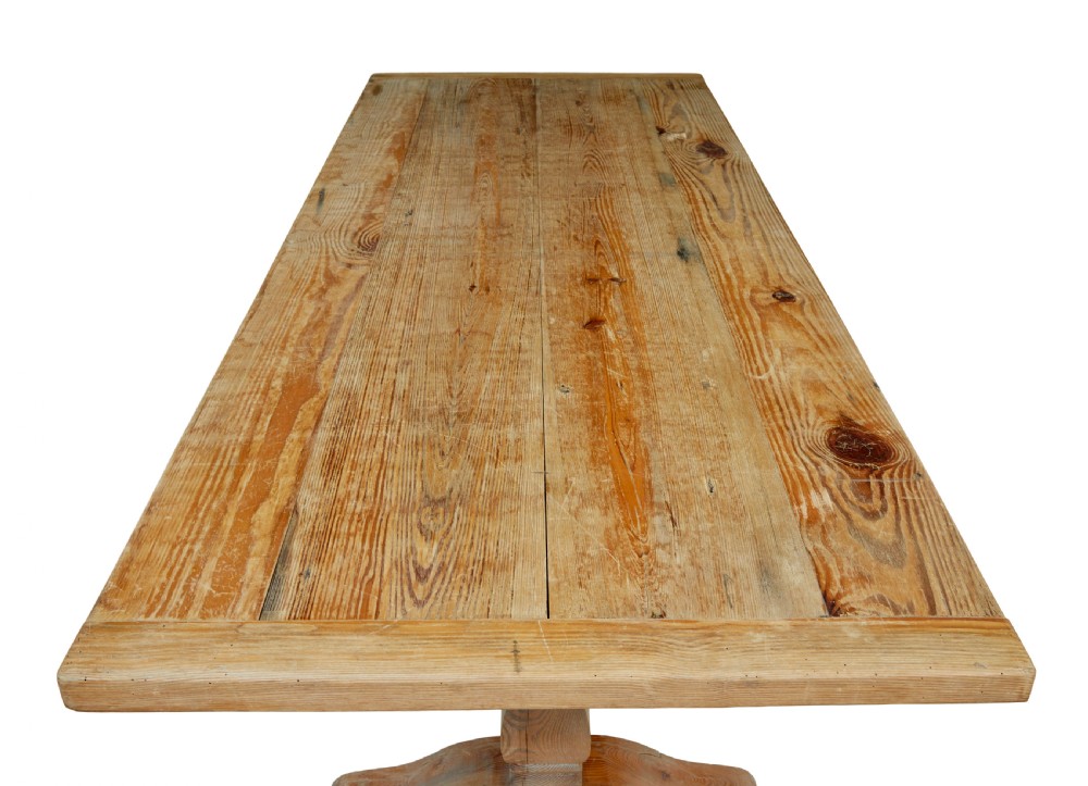 A nineteenth-century pine refectory dining table featuring a plank top, carved baluster supports, and a low central floor stretcher. View V