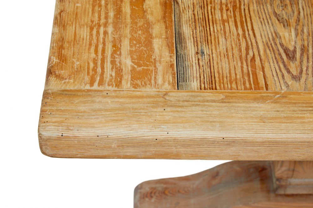 A nineteenth-century pine refectory dining table featuring a plank top, carved baluster supports, and a low central floor stretcher. View VI