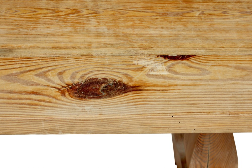 A nineteenth-century pine refectory dining table featuring a plank top, carved baluster supports, and a low central floor stretcher. View VIII