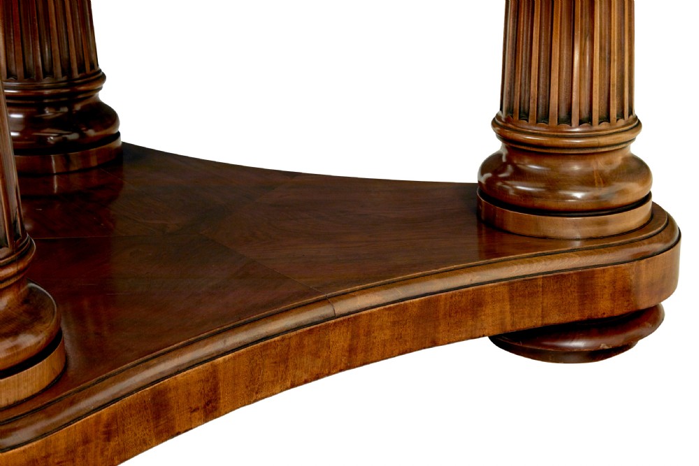 A mid 19th-century mahogany dining table featuring a broad oval top supported by three fluted column pedestals on a tri-form platform base. View VIII