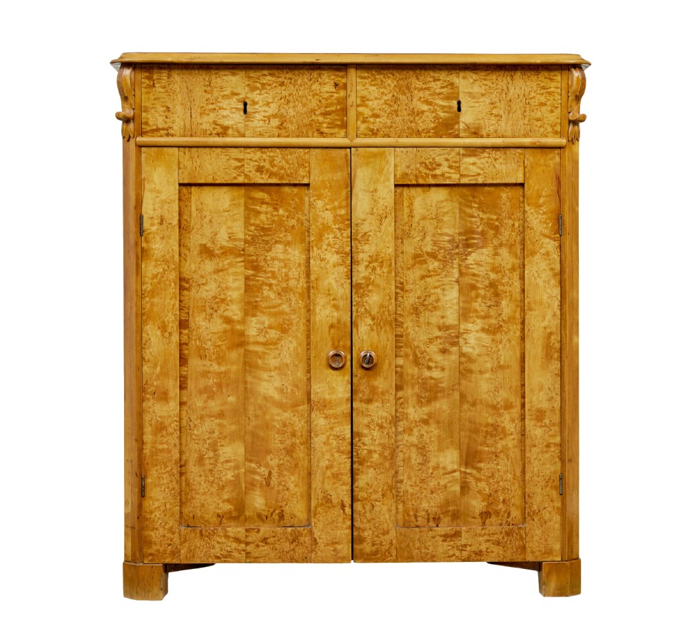 A nineteenth-century Swedish two-door cupboard constructed from golden tiger birch wood with two upper drawers and carved corner corbels. View III