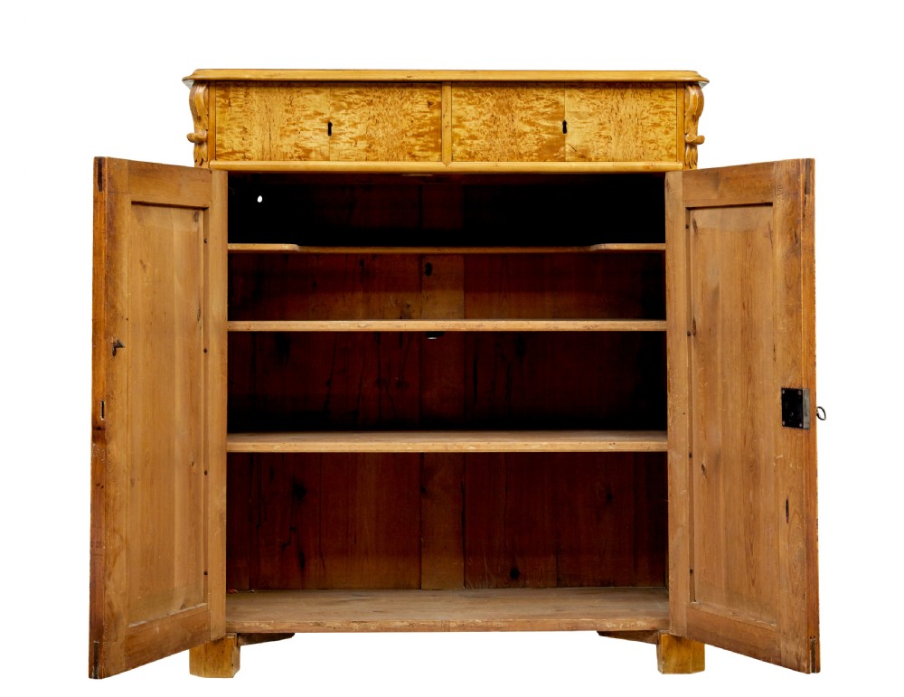 A nineteenth-century Swedish two-door cupboard constructed from golden tiger birch wood with two upper drawers and carved corner corbels. View IV