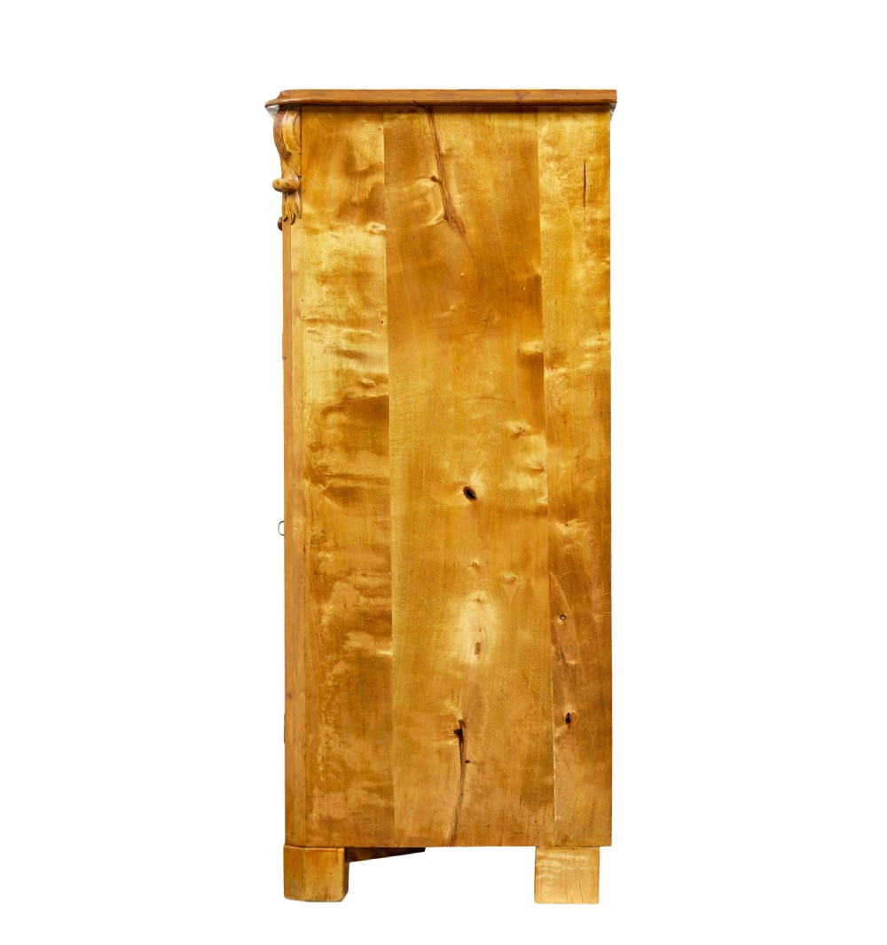 A nineteenth-century Swedish two-door cupboard constructed from golden tiger birch wood with two upper drawers and carved corner corbels. View V