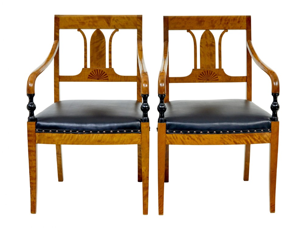 A pair of Art Deco Scandinavian birch armchairs featuring curved armrests, ebonised turned supports, inlaid back splats, and black leather studded seats. View II
