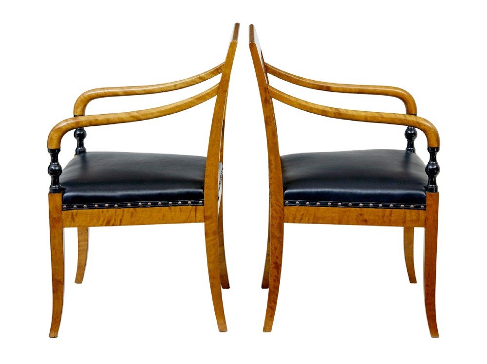 A pair of Art Deco Scandinavian birch armchairs featuring curved armrests, ebonised turned supports, inlaid back splats, and black leather studded seats. View III