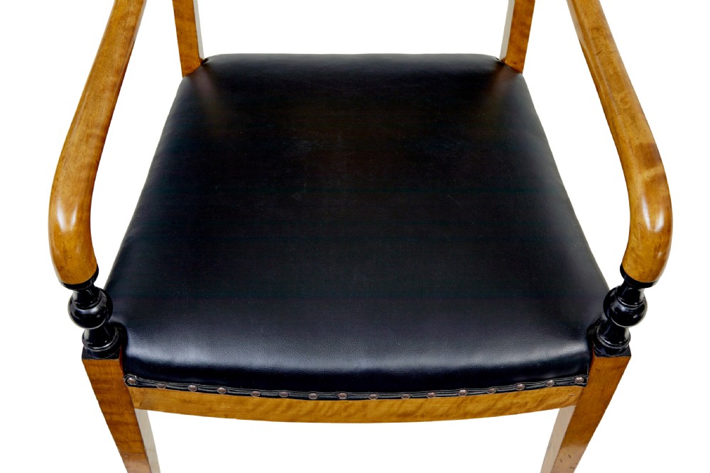 A pair of Art Deco Scandinavian birch armchairs featuring curved armrests, ebonised turned supports, inlaid back splats, and black leather studded seats. View V