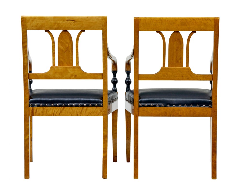 A pair of Art Deco Scandinavian birch armchairs featuring curved armrests, ebonised turned supports, inlaid back splats, and black leather studded seats. View VIII