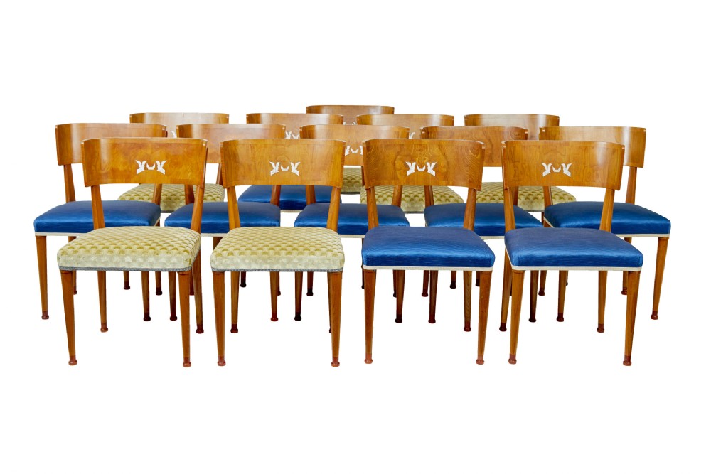 A set of Swedish Art Deco elm klismos dining chairs featuring curved backrests with marquetry inlays and upholstered seats in blue and patterned fabrics.