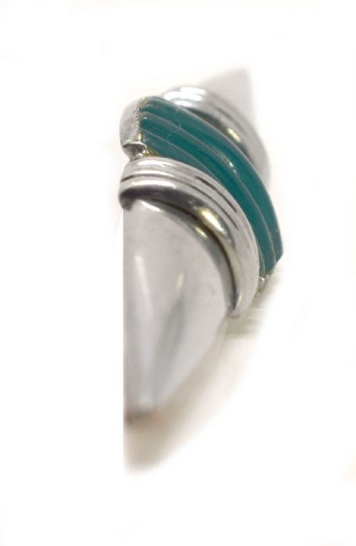 fig 1. An Art Deco chrome-plated modernist brooch featuring a central ribbed green block flanked by stepped collars and pointed conical ends.