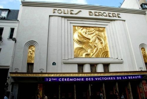 fig 1. A square metallic brass wall plaque depicting a stylised Art Deco female dancer surrounded by geometric flowing lines in low relief.