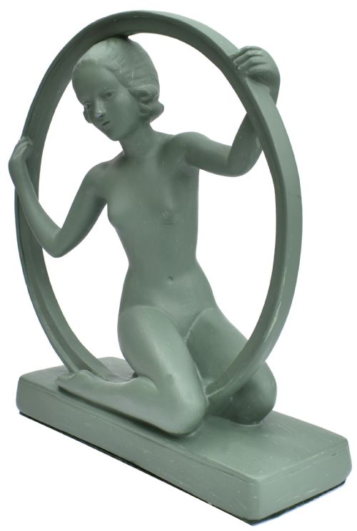 fig 1. A sage green Art Deco painted plaster figurine depicting a kneeling female figure inside a circular hoop set on a rectangular base.