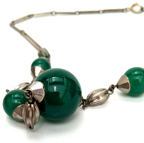 fig 1. An Art Deco necklace featuring deep green glass spherical beads fitted with fluted metal caps and connected by elongated metal bar links.