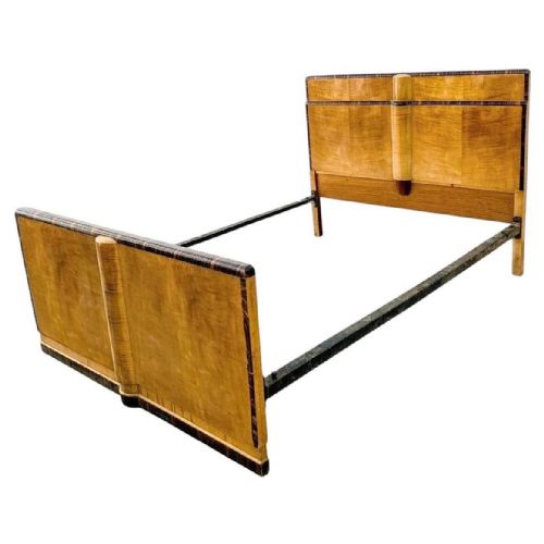 fig 1. An Art Deco blonde satinwood double bed frame featuring dark Macassar ebony crossbanding and central cylindrical accents on the headboard and footboard.