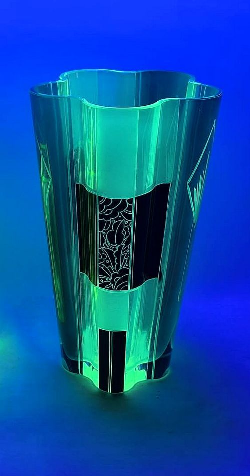 fig 1. An Art Deco uranium glass vase featuring faceted green and yellow glass panels with black enamel geometric and botanical patterns.