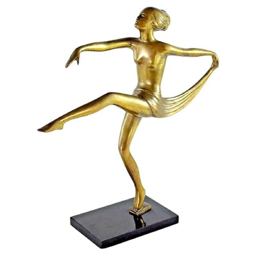 fig 3. A golden bronze Art Deco figurine depicting a nude female dancer poised in a dynamic pose on a dark rectangular wooden base.