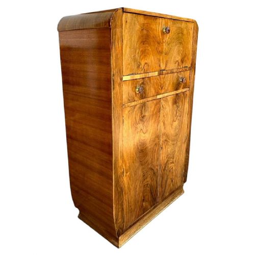 fig 1. An Art Deco figured walnut cocktail cabinet featuring a fall-front upper flap, a central drawer, and two lower cupboard doors.