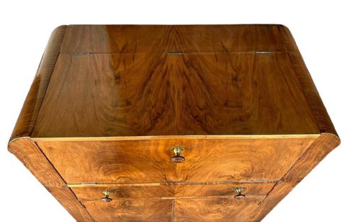 fig 2. An Art Deco figured walnut cocktail cabinet featuring a fall-front upper flap, a central drawer, and two lower cupboard doors.